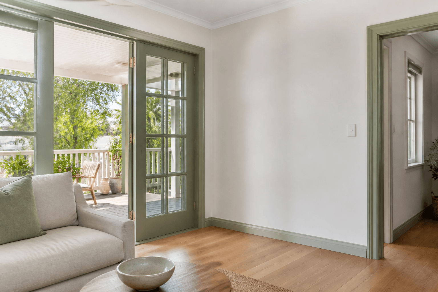 bright living room with sage-painted French doors and fresh neutral walls